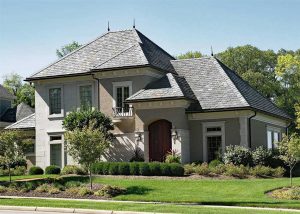 A large luxury home with an expansive front yard and new asphalt roof.