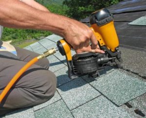 A professional roofer installs new shingles on a home